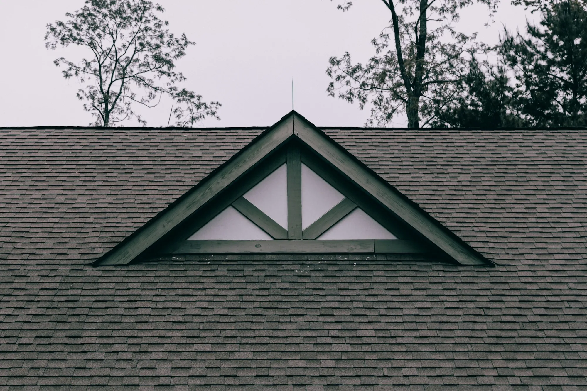 Green gable trim set into a dark gray asphalt shingle roof